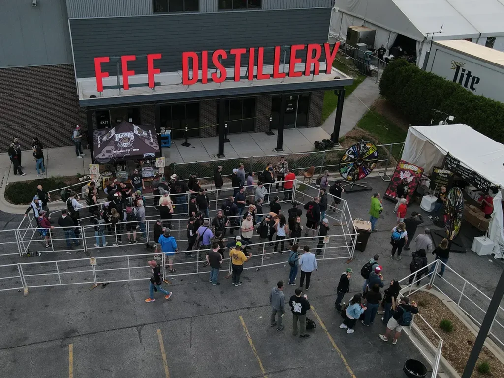 Crowds waiting outside FFF Distillery in marked lanes for event entry and merchandise.
