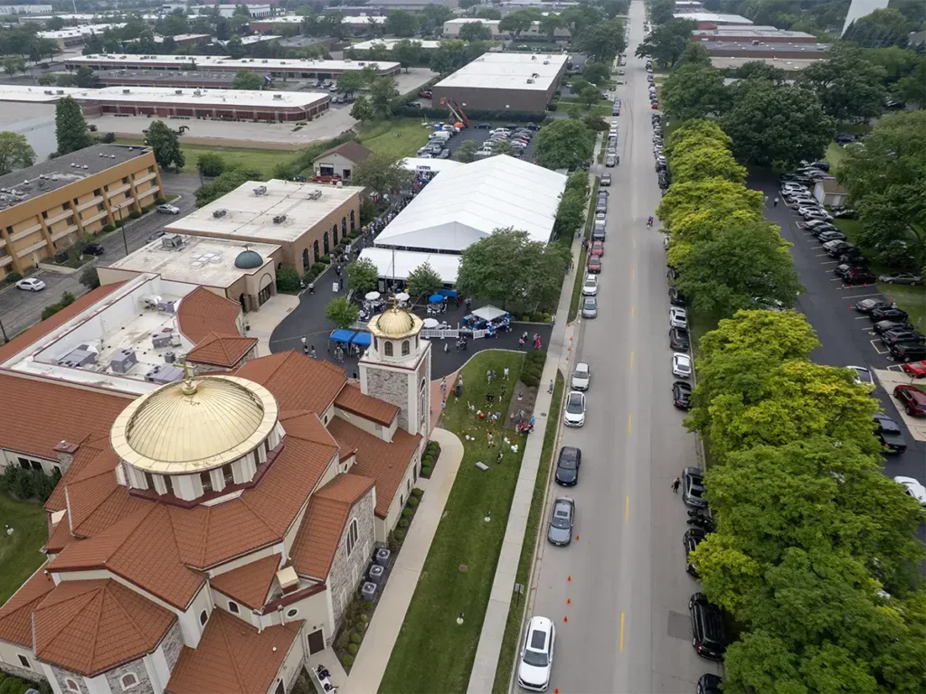 Drone photo of Saint Sophia’s parking lot transformed with white tent structures and bustling festival activity.