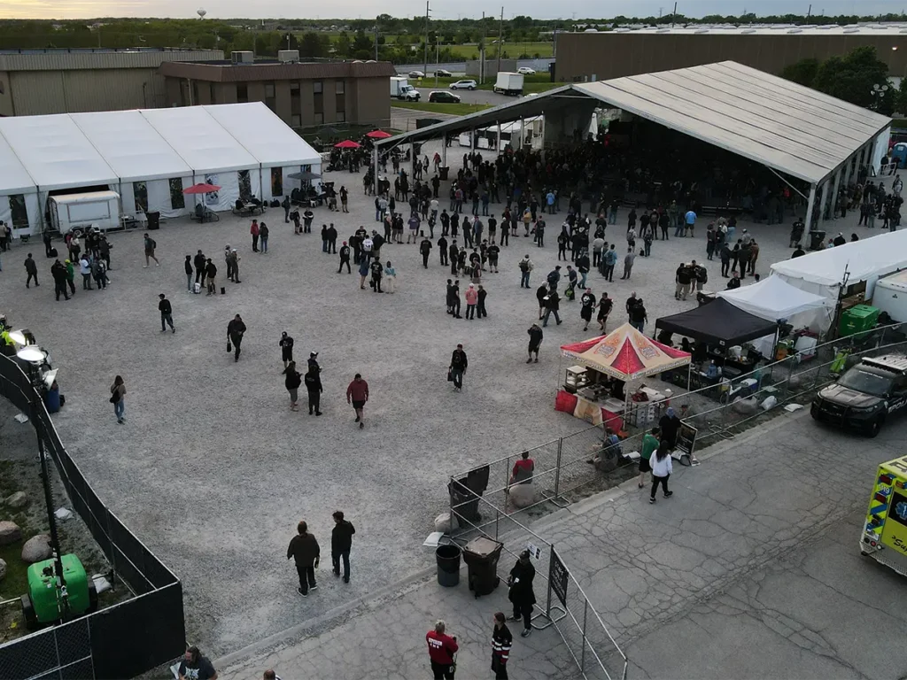 Crowds gathered in front of the main concert tent with vendors and food stalls along the side.