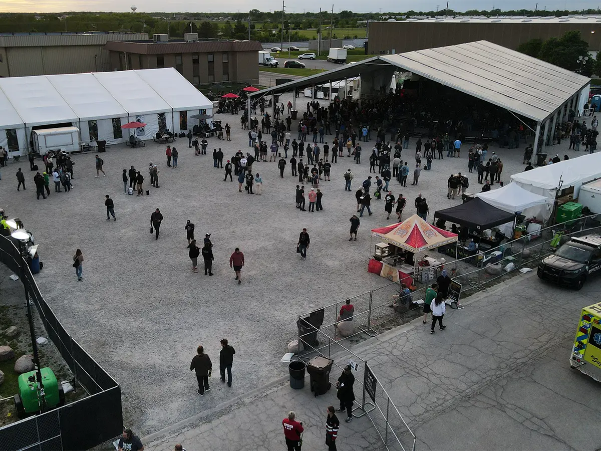 Crowds gathered in front of the main concert tent with vendors and food stalls along the side.