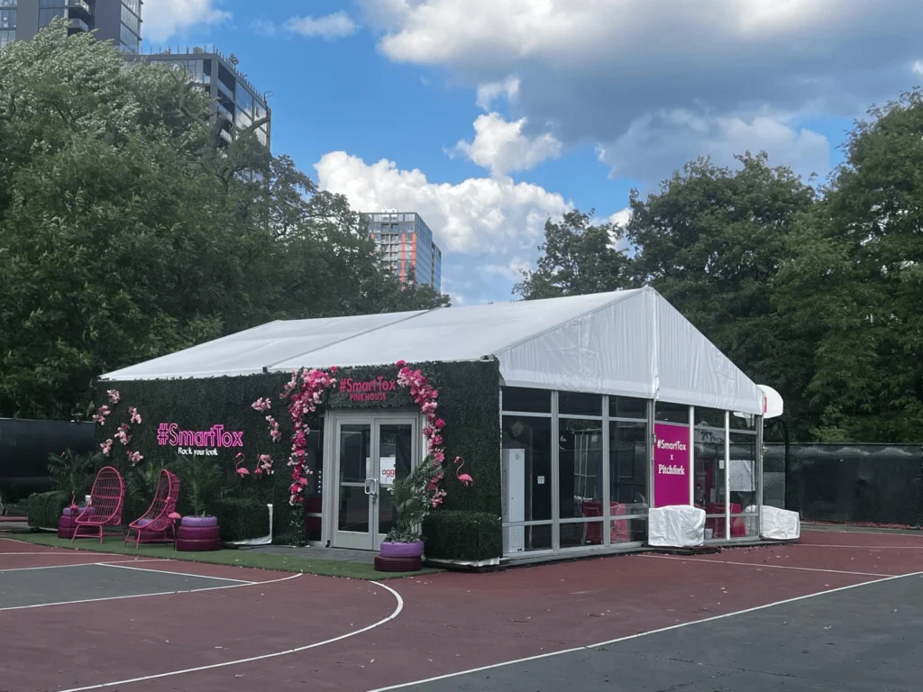 White clearspan tent wrapped in greenery and pink branding elements for SmartTox event