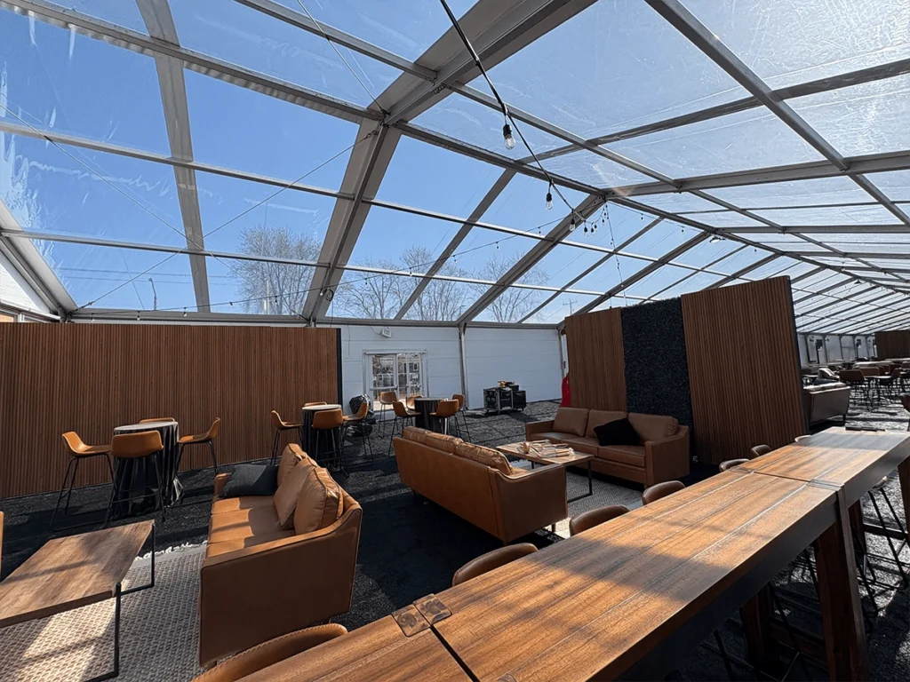 Luxury lounge interior with leather furniture under a clear tent roof.