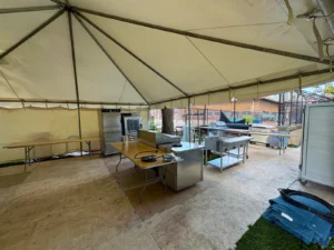 Another view inside the catering support tent at ARC, showing ovens, prep tables, and equipment organized along the tent walls.