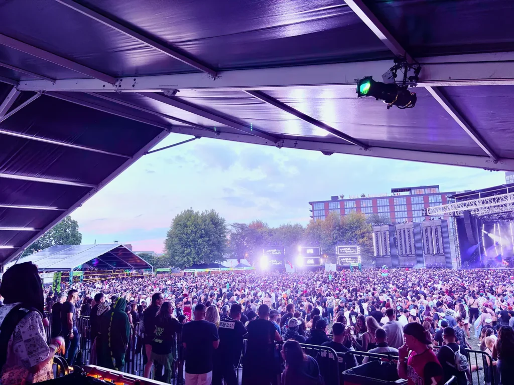 View of the ARC Music Festival main stage and crowd from inside the VIP clearspan deck, with guests watching from behind the railing.