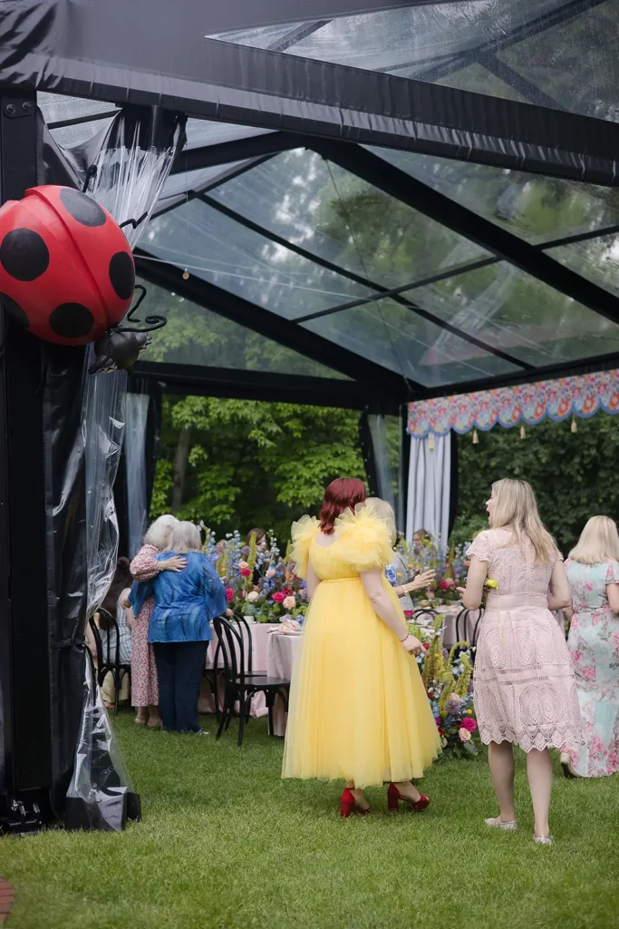 Decorative ladybug prop attached to the corner of a clear-roof tent at a baby shower.