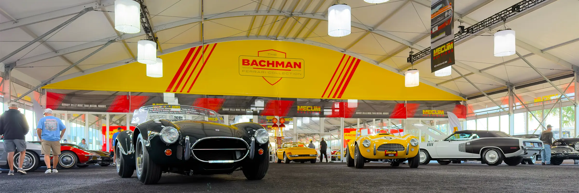 Classic cars staged under the Bachman Ferrari Collection signage inside a JK Rentals arcum clearspan at Mecum Kissimmee, FL.