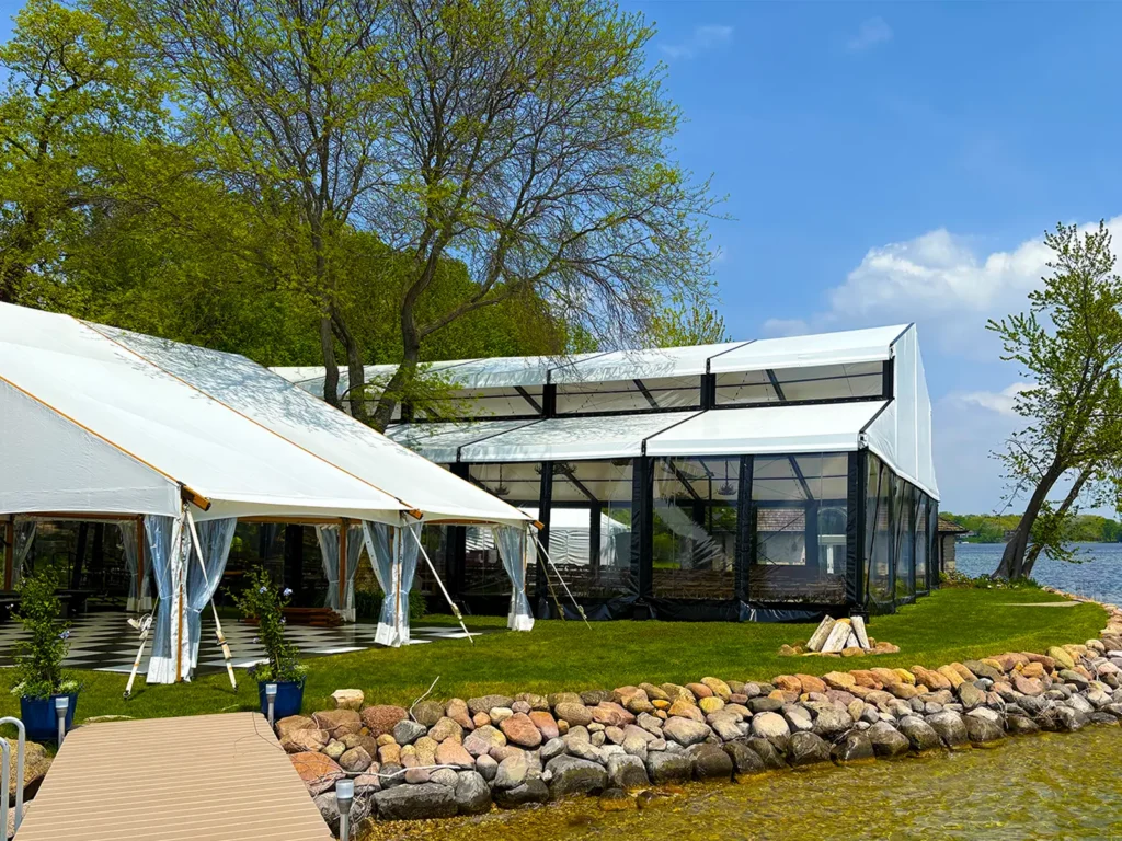 Shoreline view of the waterfront wedding tent layout with a Levo clearspan structure and support tents in Oconomowoc, Wisconsin.
