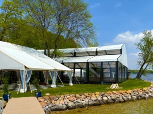 Shoreline view of the waterfront wedding tent layout with a Levo clearspan structure and support tents in Oconomowoc, Wisconsin.