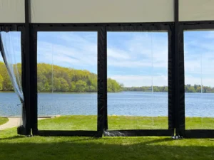 View through clear wall panels of a Levo clearspan structure looking out to a lake and spring trees in Oconomowoc, Wisconsin.