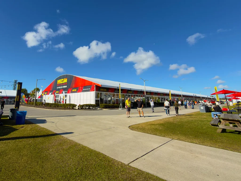 Long Mecum Auctions clearspan structure with red and black branding and glass walls in Kissimmee